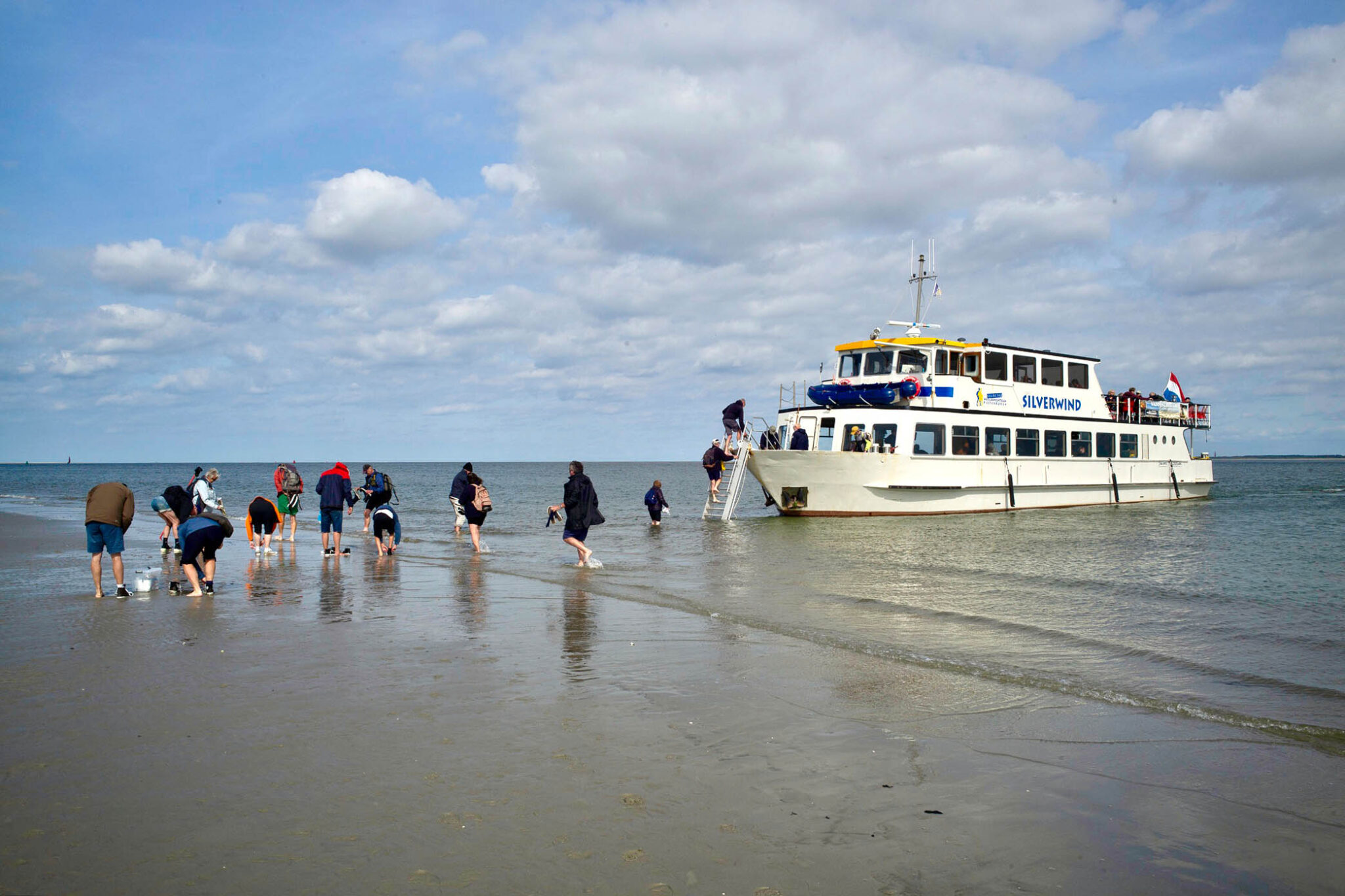 Groep NGVM-leden stap uit de boot en loopt richting Engelsmanplaat